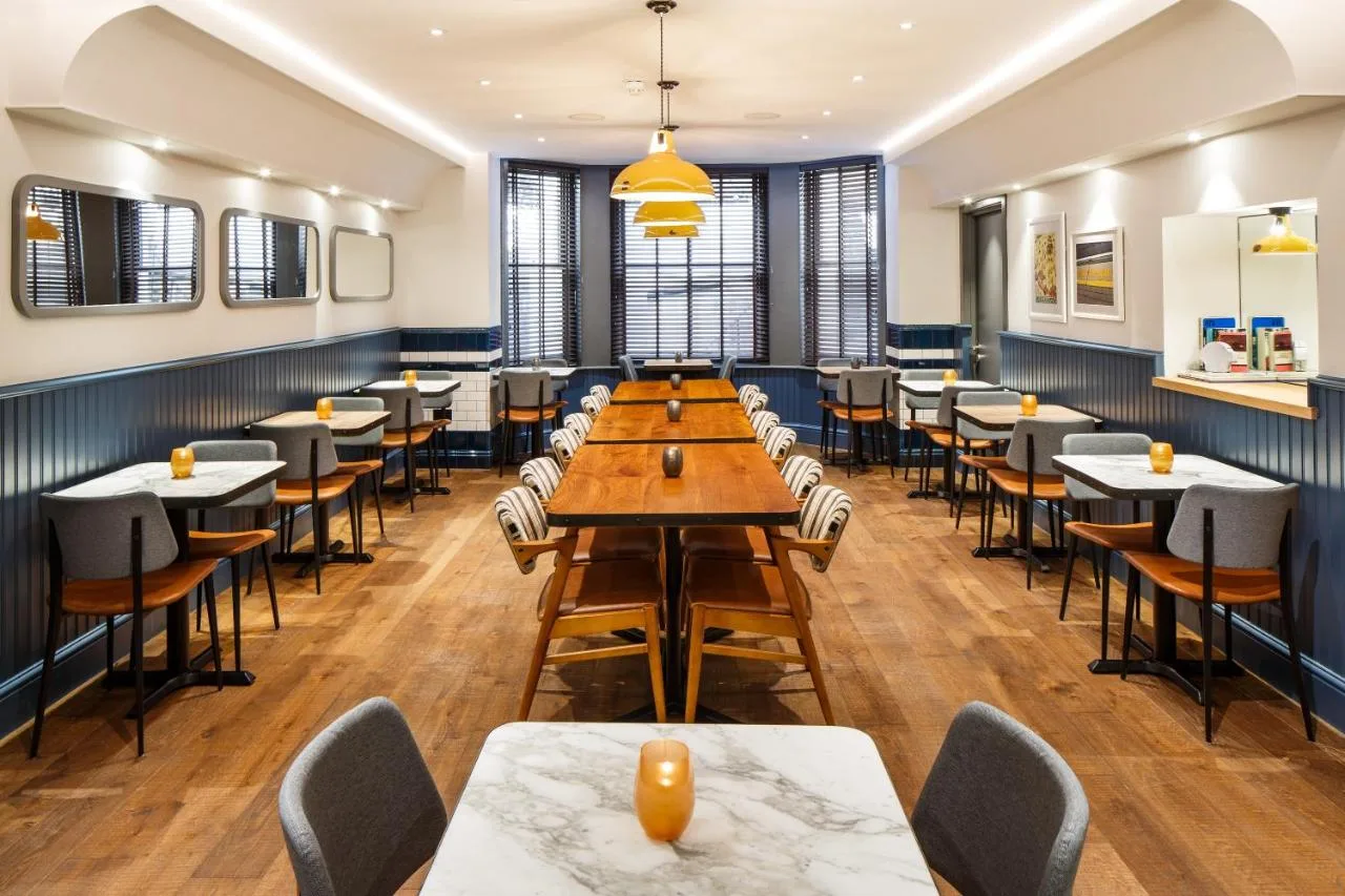 a large dining room with tables and chairs at ibis Styles London Gloucester Road in London