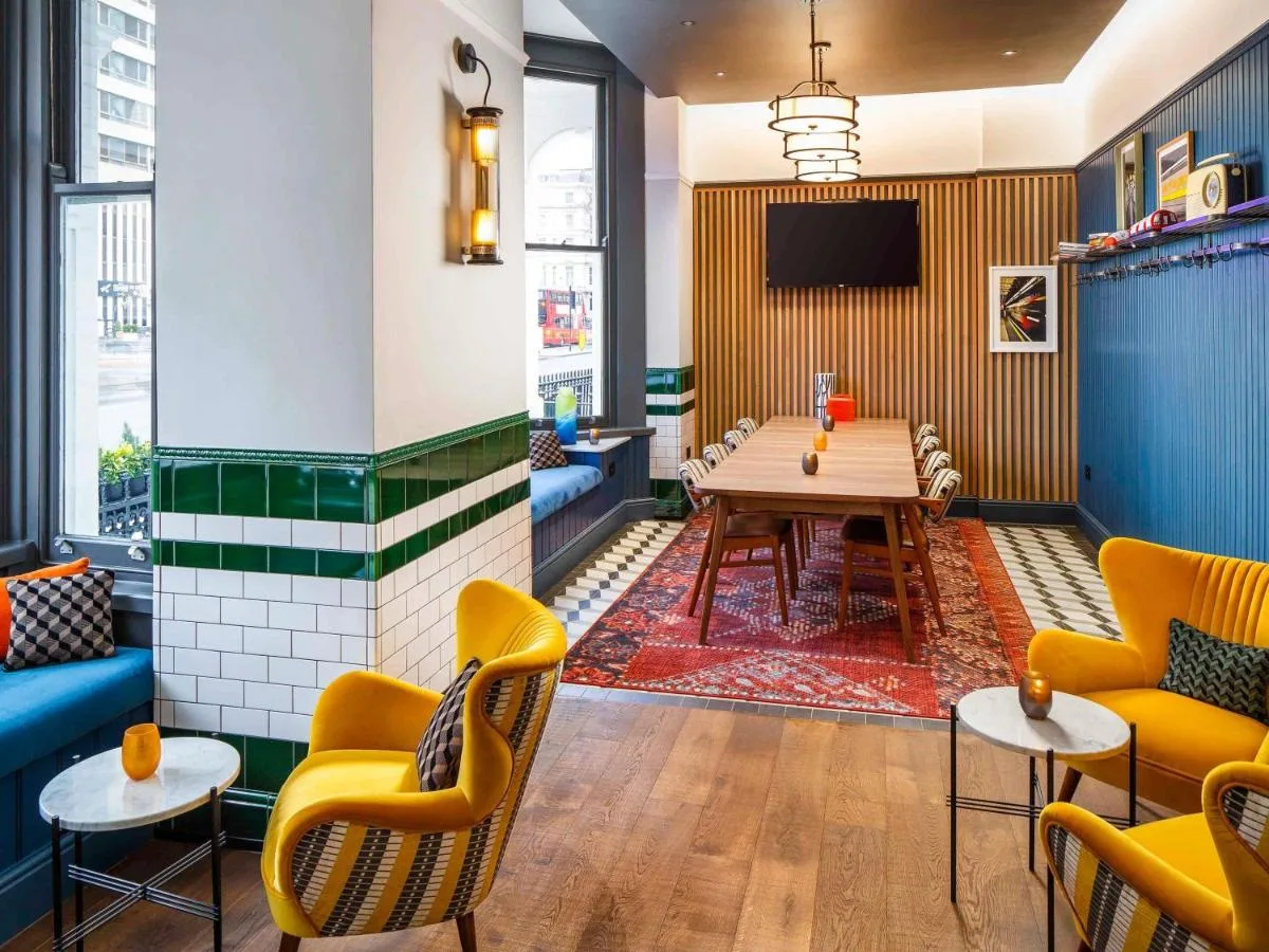 a restaurant with a table and chairs and a tv at ibis Styles London Gloucester Road in London