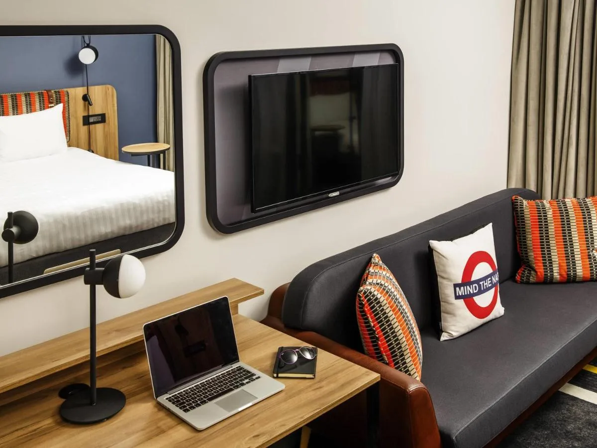 a room with a couch and a laptop on a table at ibis Styles London Gloucester Road in London